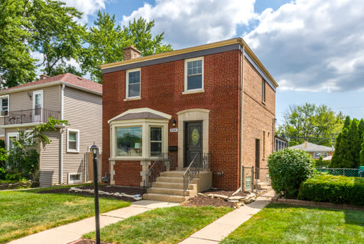 Brick two-story home with bay window and limestone trim at 9205 S Utica Ave, Evergreen Park