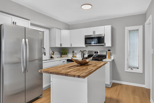 Renovated kitchen with stainless appliances and butcher-block island, 9205 S Utica Ave