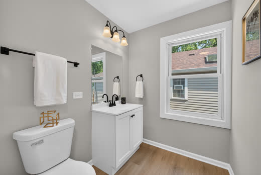Updated bathroom with white vanity and black fixtures at 9205 S Utica Ave