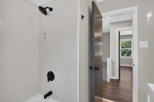 Tub shower with matte black rain showerhead detail, 9205 S Utica Ave bathroom