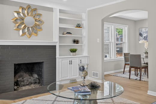 Living room with fireplace, built-in shelves, and arched doorway at 9205 S Utica Ave