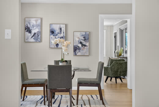 Staged dining room with glass table and new luxury vinyl plank flooring at 9205 S Utica Ave