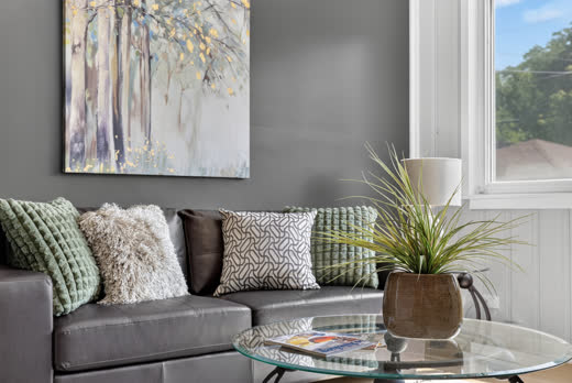 Staged sitting area with gray accent wall and glass coffee table at 9205 S Utica Ave