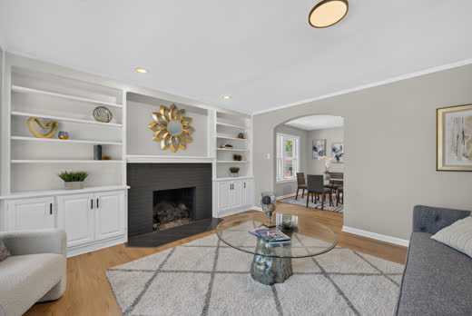 Fireplace with built-in shelving and archway to dining room at 9205 S Utica Ave