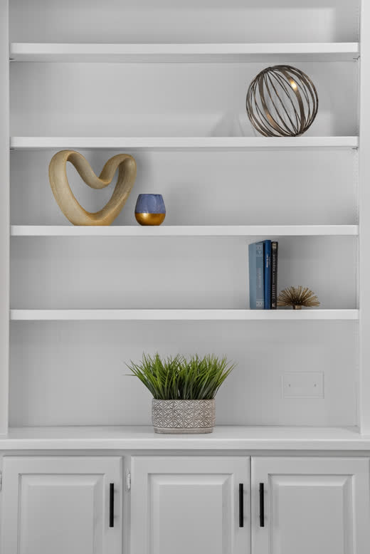 Detail of white built-in shelves with black hardware in renovated Evergreen Park home