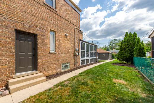 Brick side exterior with screened porch and walkway at 9205 S Utica Ave, Evergreen Park