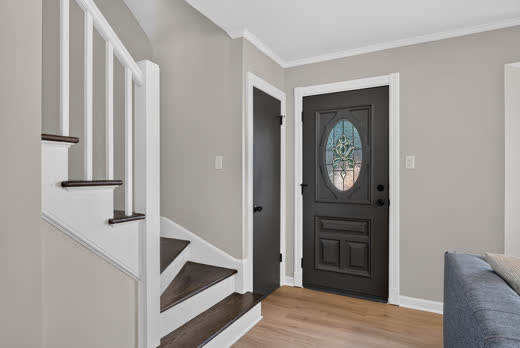 Entry foyer with decorative glass front door and staircase in Evergreen Park home