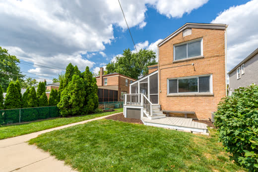 Rear exterior and landscaped backyard of 9205 S Utica Ave, Evergreen Park IL brick home