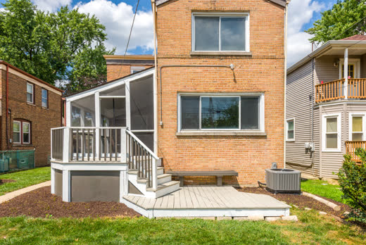 Back of brick home with screened porch and painted deck at 9205 S Utica Ave, Evergreen Park