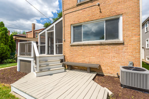 Rear deck with bench and screened porch entry at 9205 S Utica Ave, Evergreen Park IL