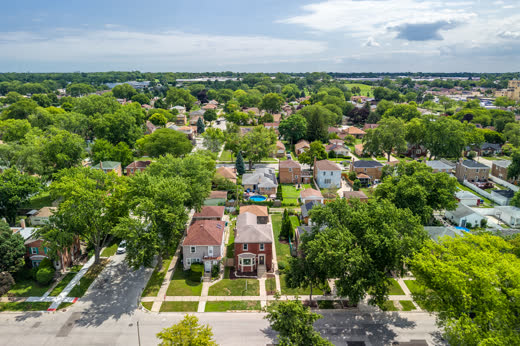 Aerial view of 9205 S Utica Ave brick home on tree-lined Evergreen Park street