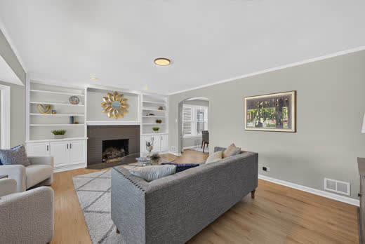 Spacious living room with fireplace built-ins and new luxury vinyl plank flooring at 9205 S Utica Ave
